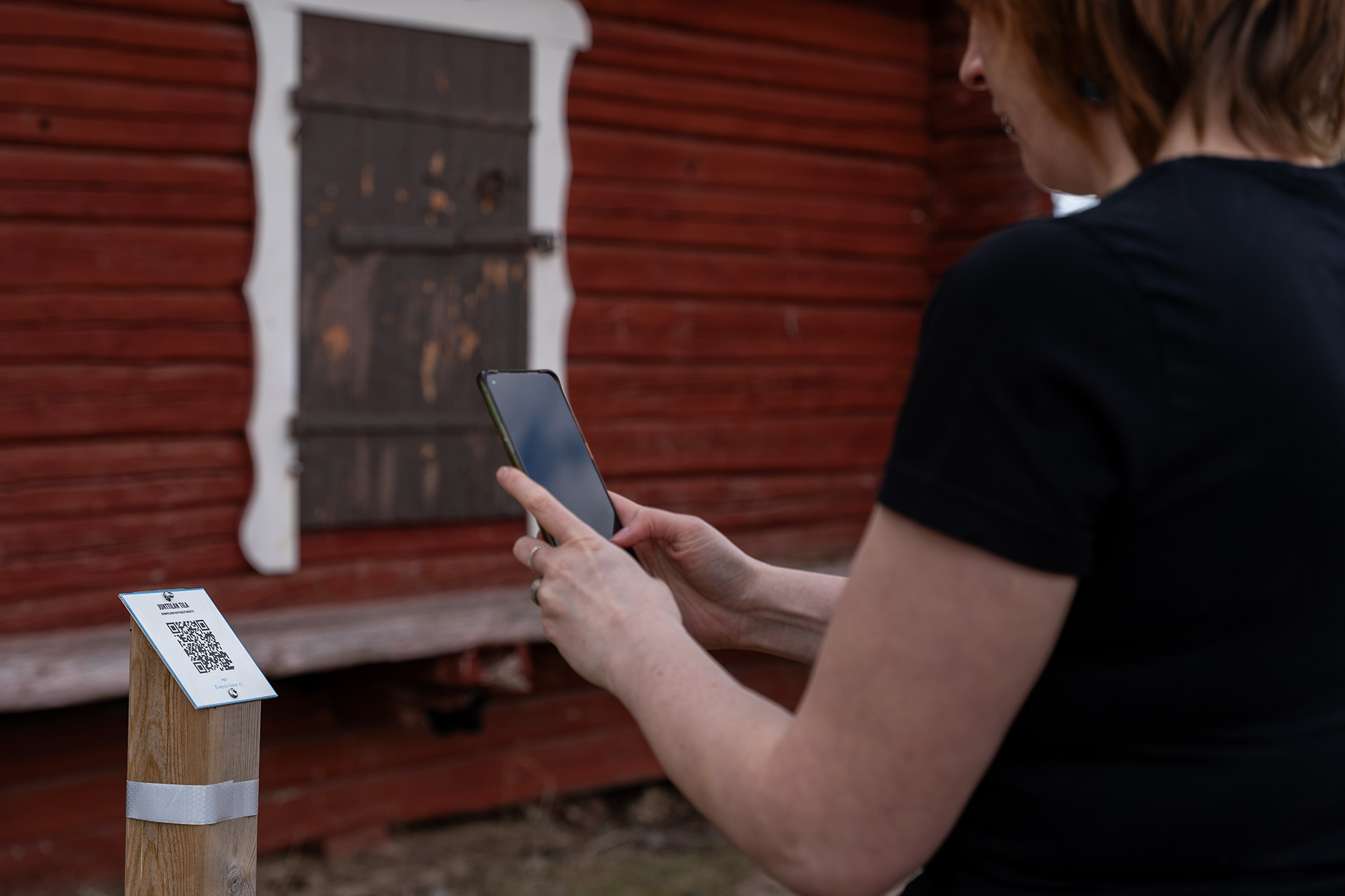 Elisa Tervonen lukee QR-koodia kotiseutureitillä.